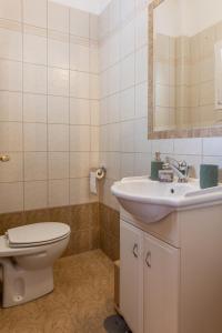 a white bathroom with a toilet and a sink at The Olympus Estate in Litochoro