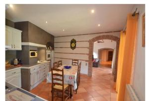 a kitchen with a table and a dining room at Grande maison avec piscine chauffée privée en Quercy in Lacour