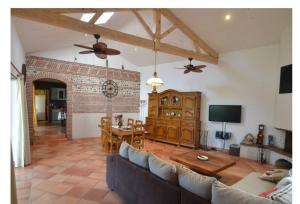 a living room with a couch and a table at Grande maison avec piscine chauffée privée en Quercy in Lacour