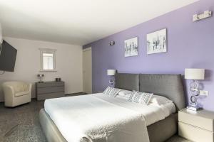 a bedroom with a large bed and a purple wall at Villa Nicolette sleeps 8 in Menaggio