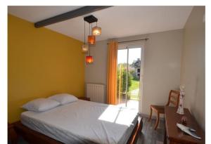 a bedroom with a bed and a table and a window at Grande maison avec piscine chauffée privée en Quercy in Lacour +47 photos