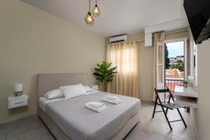 Schlafzimmer mit einem Bett, einem Schreibtisch und einem Balkon in der Unterkunft Maravelia's Rooms in Symi