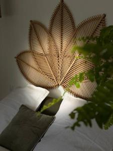 Una cama con un cabecero de flores y una planta en La Petite Grange - Spa Balnéo, en Vigneux-de-Bretagne