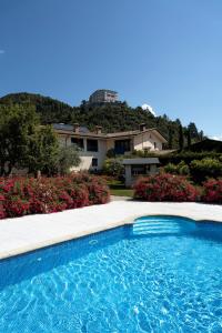 a swimming pool in front of a house with flowers at Agriturismo La Dolza in Follina