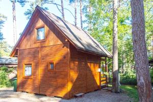 a small wooden cabin in the woods with trees at O.W.Sztil in Pobierowo
