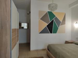 萊里奇的住宿－La Casetta di Gio' con Parcheggio，卧室配有一张床,墙上挂有绘画作品