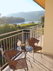 eine Terrasse mit einem Tisch und Stühlen auf dem Balkon in der Unterkunft Gartenhotel & Weingut Pfeffel Dürnstein in Dürnstein