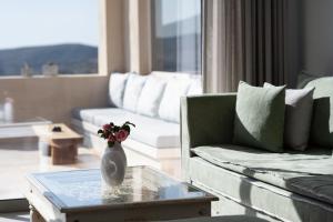 a living room with a vase with flowers on a table at Youtopia Ios Villas in Ios Chora