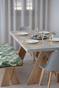 a table with plates and glasses on top of it at Youtopia Ios Villas in Ios Chora