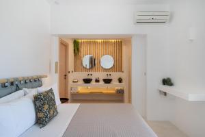 a bedroom with a bed and a bathroom with a sink at Youtopia Ios Villas in Ios Chora