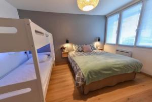 a bedroom with a bed and two windows at Marché Arago (3min), plage (8min), jardin clos. in Les Sables-dʼOlonne