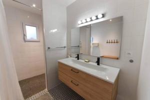ein Bad mit einem Waschbecken und einem Spiegel in der Unterkunft Marché Arago (3min), plage (8min), jardin clos. in Les Sables-dʼOlonne
