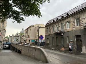 una mujer caminando por una calle al lado de edificios en Apartment in the center of Tbilisi, en Tiflis