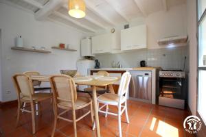 eine Küche mit einem Tisch und Stühlen im Zimmer in der Unterkunft Gîte Aussos 