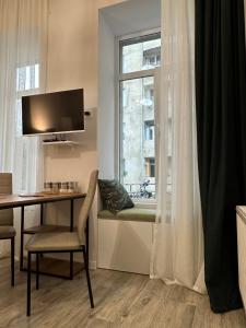 Una sala de estar con una mesa y una ventana. en Apartment in the center of Tbilisi, en Tiflis