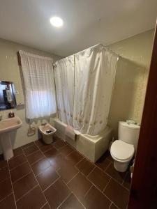 een badkamer met een toilet, een bad en een wastafel bij Casa El Lloreu in Antimio de Abajo