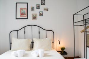 a bedroom with a bed with white sheets and pictures on the wall at Goodgarden Downtown Apartment in Porto
