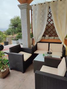 a patio with wicker chairs and a table at Apartment M&J - Valledoria - LA Muddizza - Free WI-FI in Valledoria
