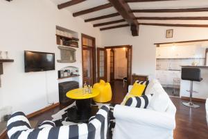 a living room with white and yellow furniture and a table at Vista Menaggio Centro in Menaggio