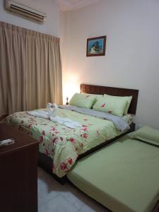 1 dormitorio con 2 camas y toallas. en Sofea Inn Bukit Merah - Laketown A6172 en Kampong Selemat