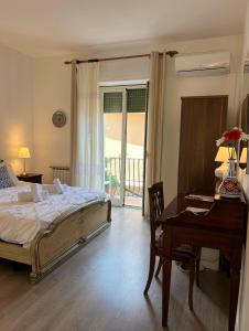 Schlafzimmer mit einem Bett, einem Schreibtisch und einem Tisch in der Unterkunft La Guardiola Di Angela e Nino in Taormina
