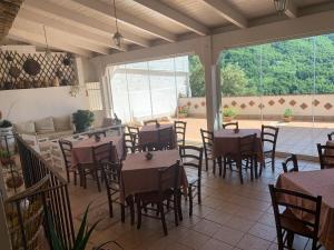 ein Restaurant mit Tischen und Stühlen auf einer Terrasse in der Unterkunft Bed e Breakfast Erica in Conflenti Inferiore