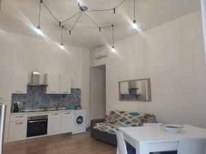 a kitchen and living room with a table and a couch at Casa Vacanze Lungomare in Piombino