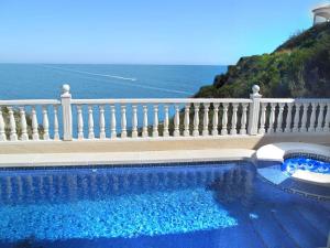 - une piscine en face d'une clôture blanche et de l'océan dans l'établissement VILLA BUENA VISTA, à Cumbre del Sol