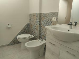 a white bathroom with a sink and a toilet at Casa Vacanze Lungomare in Piombino