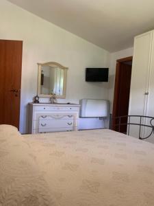 Schlafzimmer mit einem Bett, einer Kommode und einem Spiegel in der Unterkunft Bed e Breakfast Erica in Conflenti Inferiore