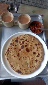 a tortilla on a plate on a tray with bowls of food at Deelux cottages inn in Chail