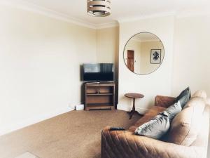 a living room with a couch and a mirror at Views over the Peak District Apartment with WIFI in Sheffield