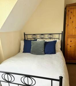 a bed with blue pillows on it in a room at Views over the Peak District Apartment with WIFI in Sheffield