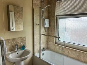 a bathroom with a sink and a tub and a shower at Views over the Peak District Apartment with WIFI in Sheffield