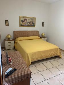 Un dormitorio con una cama amarilla y una mesa en Bed e Breakfast Erica en Conflenti Inferiore