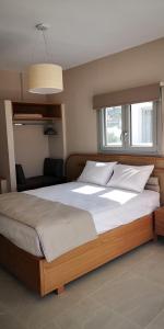 1 cama grande en un dormitorio con ventana en Lemonia Rooms, en Platis Yialos Sifnos