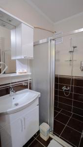 W łazience znajduje się biała umywalka i prysznic. w obiekcie GRAND FAMILY HOME w mieście Soğuksu