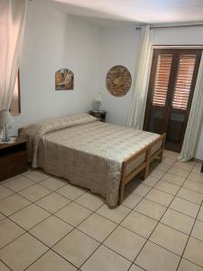 um quarto com uma cama e piso em azulejo em Bed e Breakfast Erica em Conflenti Inferiore