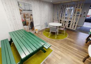 a room with a green bench and tables and chairs at iQ Ty Willis House in Bangor 3 Min Walk to Bangor Station in Bangor