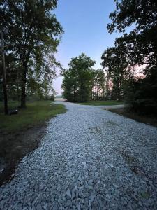 a gravel road with trees on either side at Whiskey Woods Retreat in Tullahoma