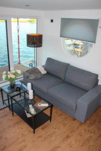 uma sala de estar com um sofá e uma mesa em Hausboot Wangermeer Nordsonne12 mit Sauna em Wangerland