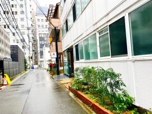 una calle vacía al lado de un edificio con plantas en 301 サンライズマンション新大阪駅から徒歩2分！Guest Room Shin-Osaka en Osaka