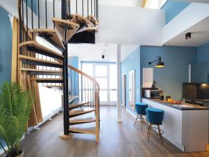 - un escalier en colimaçon dans une cuisine aux murs bleus dans l'établissement Seebrücke Heringsdorf - Appartement mit 2 Schlafzimmern und Terrasse S17, à Heringsdorf