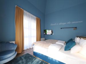 a blue bedroom with a bed and a window at Seebrücke Heringsdorf - Appartement mit 2 Schlafzimmern und Terrasse S17 in Heringsdorf