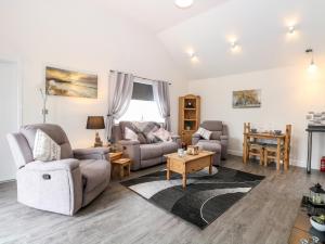 a living room with a couch and chairs and a table at Kingfisher Lodge in Great Yarmouth