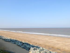a beach with a bunch of rocks and the ocean at Kingfisher Lodge in Great Yarmouth