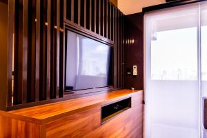 a living room with a large flat screen tv at Loft Campolim in Sorocaba