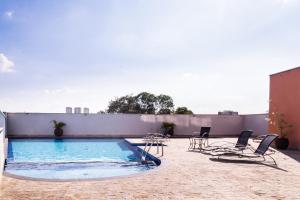 a swimming pool on the roof of a building at Loft Campolim in Sorocaba