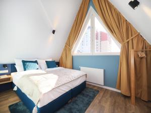 ein Schlafzimmer mit einem Bett und einem großen Fenster in der Unterkunft Seebrücke Heringsdorf - Appartement mit 2 Schlafzimmern S20 in Heringsdorf