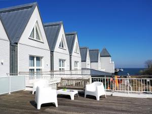 eine Terrasse mit weißen Stühlen und eine Reihe von Häusern in der Unterkunft Seebrücke Heringsdorf - Appartement mit 2 Schlafzimmern S20 in Heringsdorf